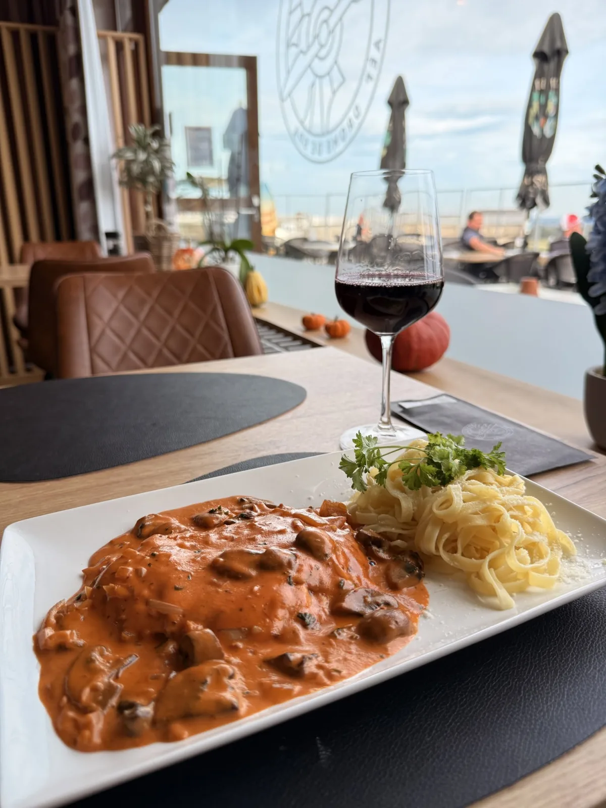 Un repas et un verre de vin servis au Sunset avec la terrasse en arrière-plan